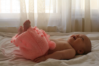 Neve wearing pink knitted pom-pom skirt.