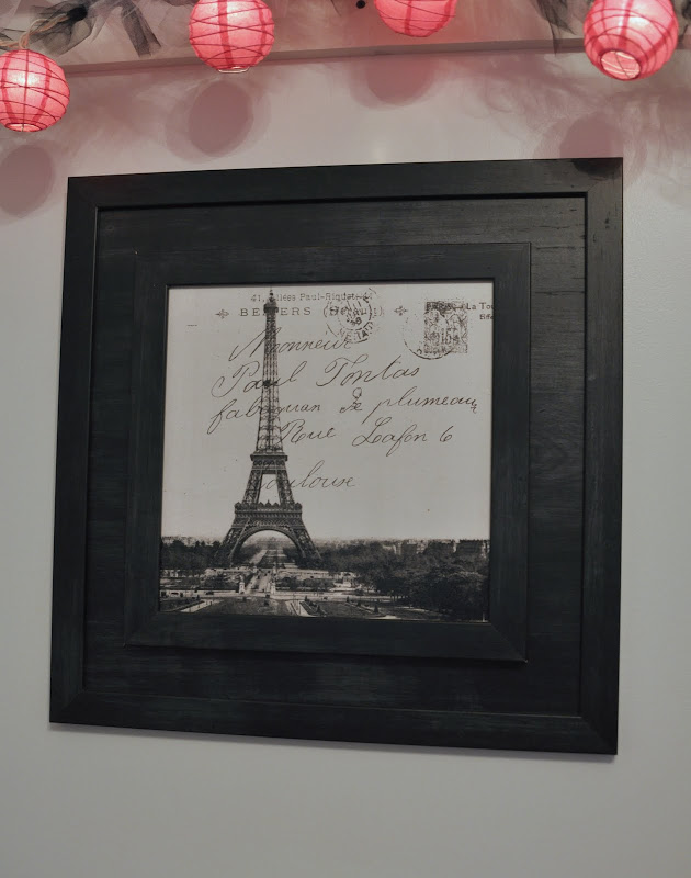 An up close look at the Paris picture above her bed. title=