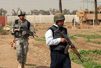 Spc. Dane Bamford (left), from Shamokin, Pa., searches with an Iraqi policeman during a joint operation at Baghdad University College of Agriculture March 21. As Iraqi Security Forces step into a larger role, U.S. troops will step back, allowing for less stress on forces and more 'home time' for troops.