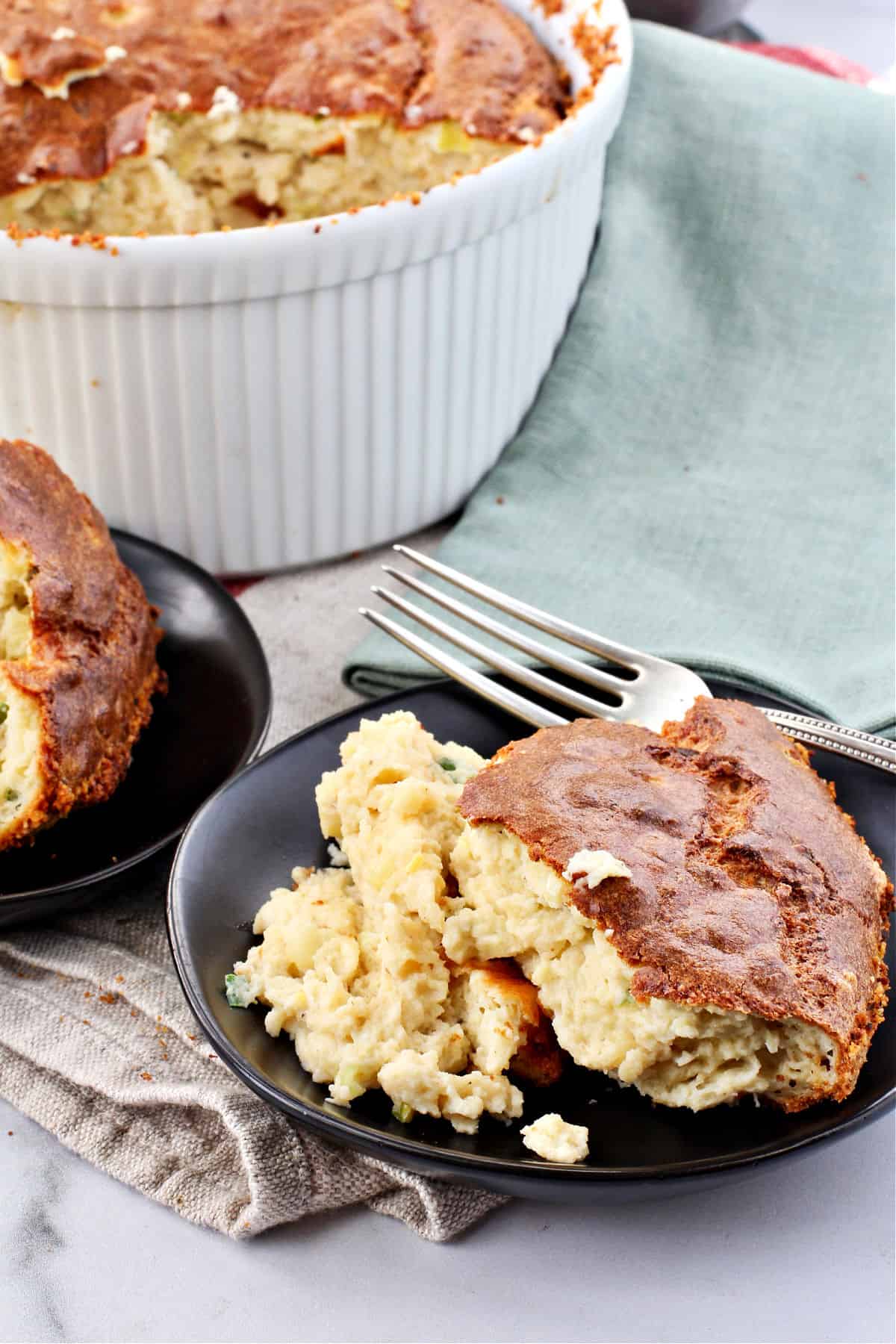 Corn Soufflé with servings on small black plates.