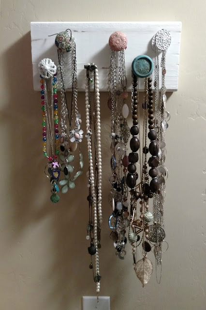 Make your own hanging necklace holder using a piece of scrap wood and some cute drawer knobs!