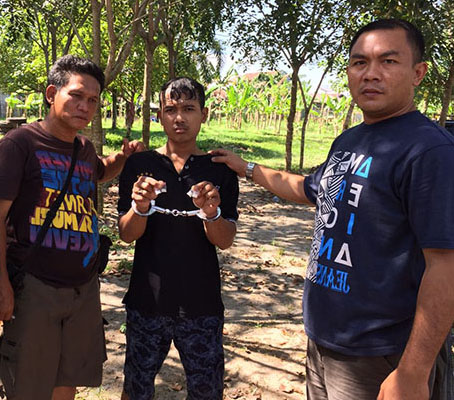 Tersangka saat diringkus polisi di kepun milik warga.