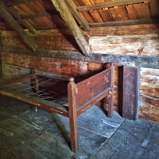 A mid 17th century bedframe in a wooden room
