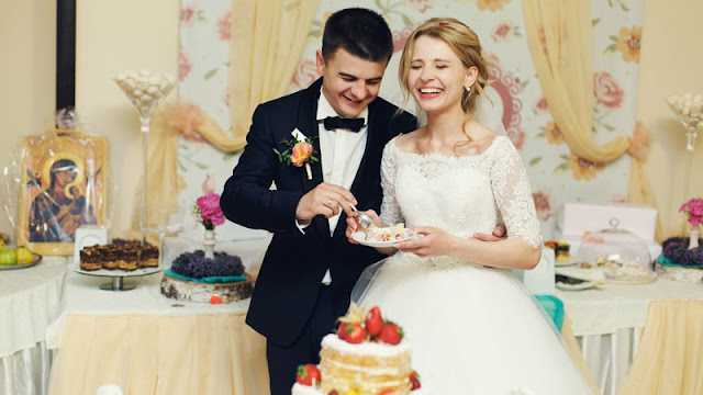 bride and groom in front of desserts