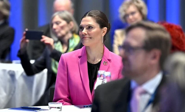 Crown Princess Victoria wore a tailored buttoned fuchsia blazer by Zara, and fuchsia full length pants by Zara. By Malina