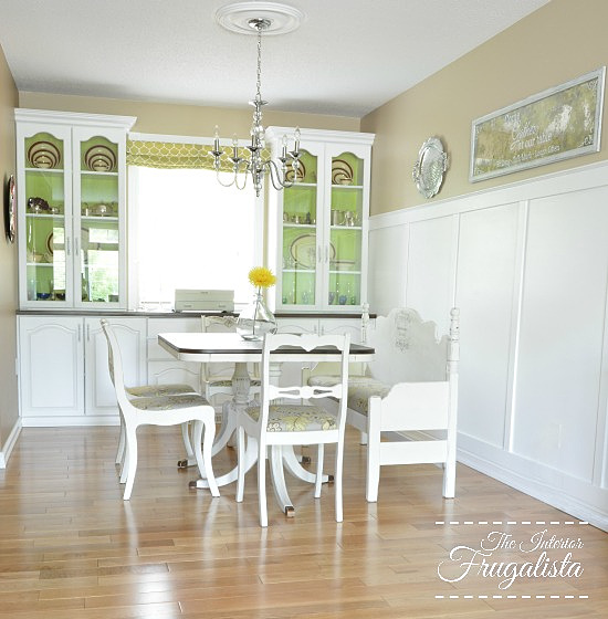 A much brighter DIY dining room makeover after with painted white cabinets and white wainscotting feature wall.
