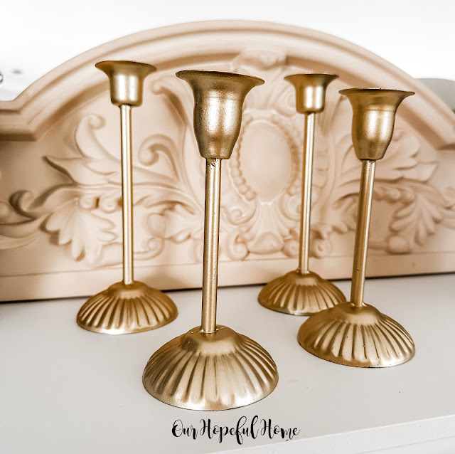 four gold taper candleholders