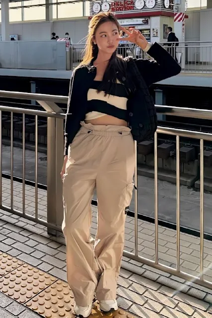 Bua Nalinthip wearing combination of a black and white crop top, black outer, and beige cargo pants