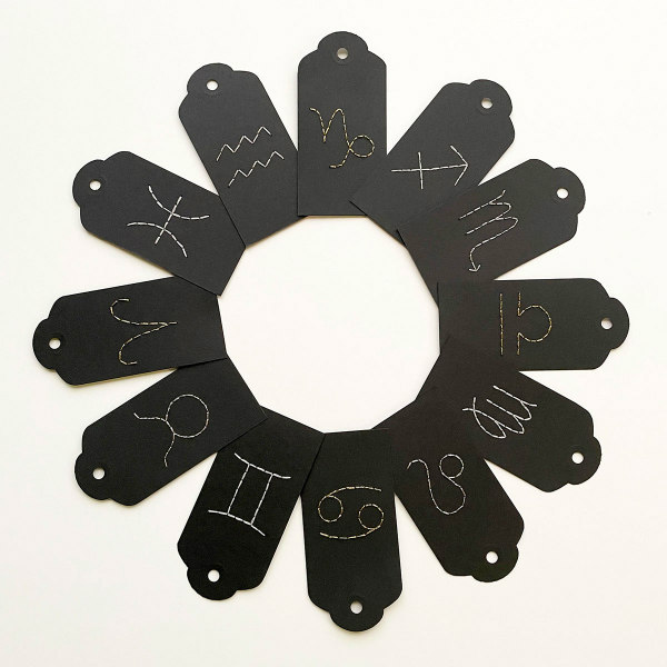 twelve black paper embroidery zodiac gift tags arranged in circle