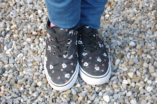 A pair of black canvas shoes with several small Mickey Mouse faces on them