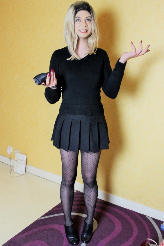 Beautiful crossdresser with an all black look and polka dot pantyhose