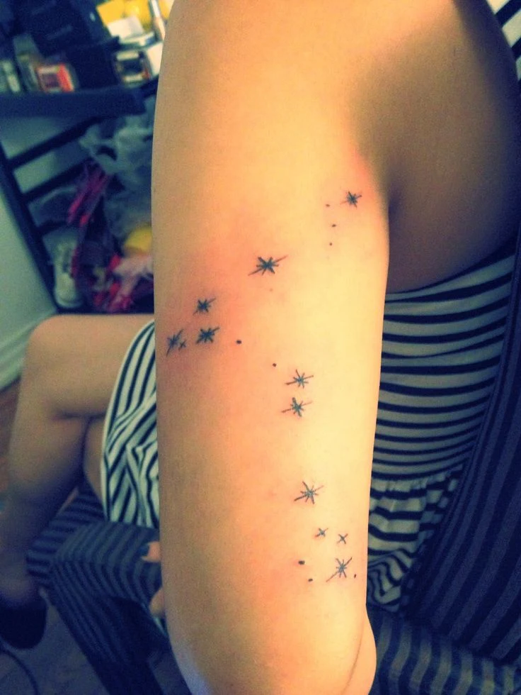 chica con tatuaje de la constelación de piscis en el brazo