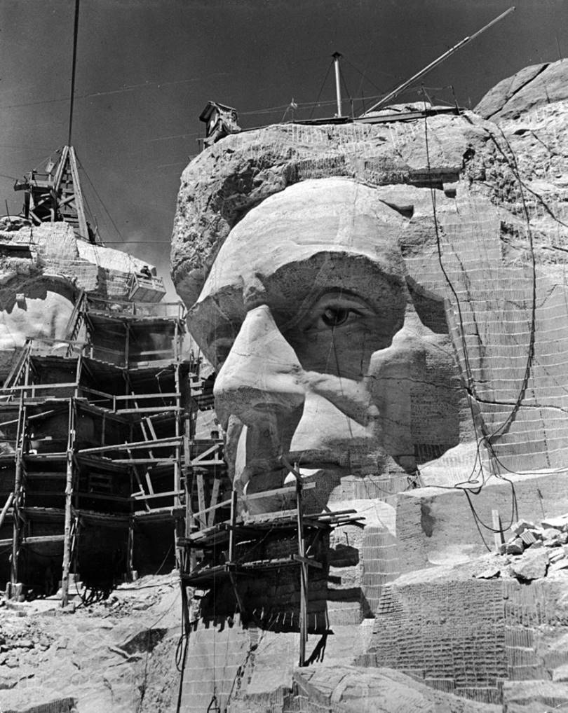 Scaffolding around a sculpture of Abraham Lincoln partially carved from a rock, circa 1941.