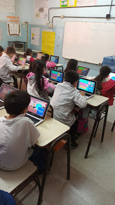 Foto 1: alumnos sentados frente a la computadora jugando Aventuras en el Ciberespacio.