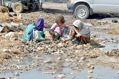 Poor Pakistani Children eating fom Rubble and Trash
