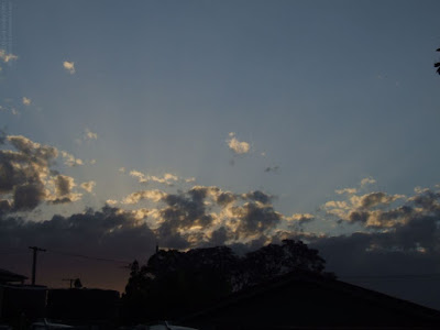 sunset - the sun behind clouds at twilight with red glow on the horizon