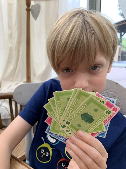 Bank attack game. Child holds millions of notes