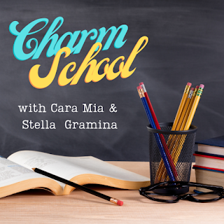 classroom stock image showing a desk in front of a chalkboard. Text over top of the chalkboard reads "Charm School" in light blue and yellow curvy lettering, and "with Cara Mia and Stella Gramina" in smaller white text. On the light wood colored desk is an open book with a pencil, next to a pencil cup containing various pencils. A pair of reading glasses sits in front of the pencil cup, and a stack of books is visible at the right edge of the image.