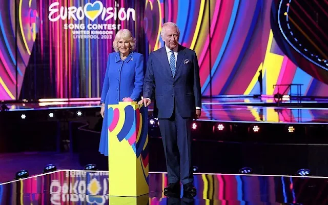 King Charles and Queen Camilla met with Eurovision contestant Mae Muller. The Queen wore a blue wool coat. Eurovision 2023