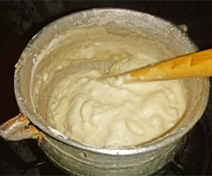 Corn dough mixture thickening in the process of cooking banku - image
