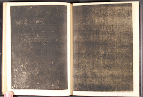 An open book, both pages filled in with ink.