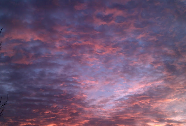 pink and grey clouds against a blue sky