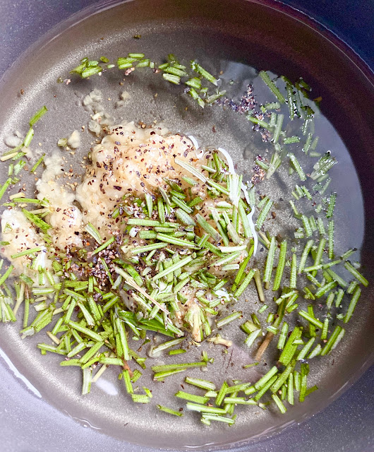 Saucepan of rosemary, garlic and pepper infused olive oil.