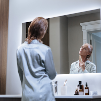 Mom going through her self-care ritual in front of the mirror