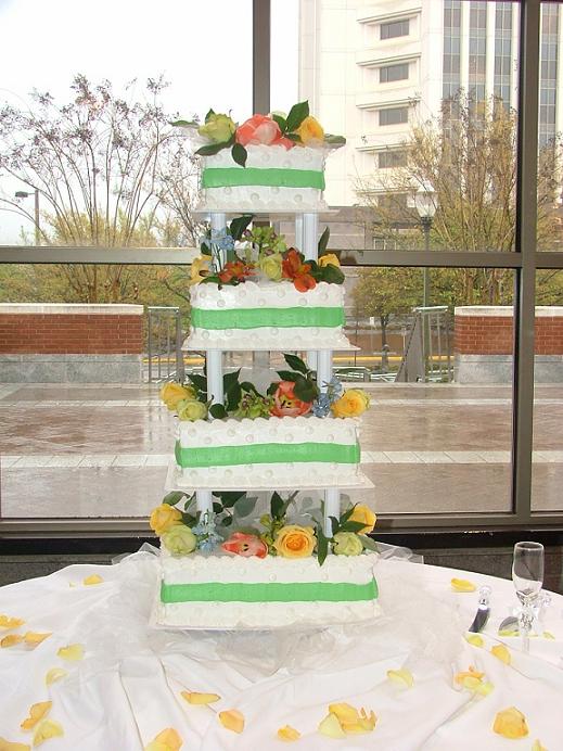 Amazing four tier wedding cake with fresh roses and green trimming