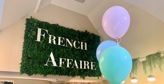 Sign for French Affaire restaurant, with balloons in the foreground