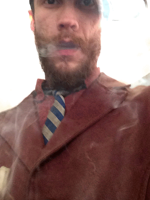 OLB with silly look blowing smoke with blue striped tie