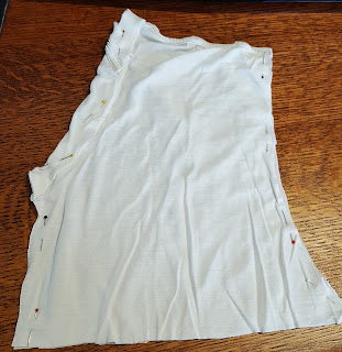 Irregularly shaped tshirt scraps, from top of one side of tshirt, pinned on three sides