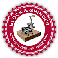 Red circular postage stamp logo with the words Block & Grinder at the top of the circle and image of an old-fashioned meat grinder in a white circular center. The words butcher's shop - prime steaks-burgers & more are in the bottom half of the red circle.