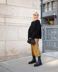 Fall Outfit Idea Stepsofstyle in Oversized Black Sweater, Bottega Veneta Clutch Bag, Camel Silk Midi Skirt, and Black Lug Sole Boots