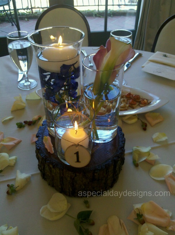 Submerged wedding centerpieces of blue delphinium with floating candle 