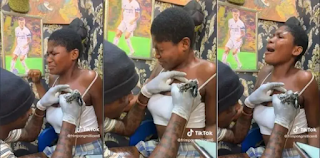 "You haven't seen anything yet" ~ Reactions stirs as lady cry in pain while getting tattoos drawn on her chest [video]