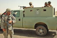 Spc. Donald Hock, the senior medic for the Combat Operating Base Speicher Security Detachment, provides security April 3 alongside a truck of Iraqi army soldiers tasked with guarding oil lines near Tikrit. On the truck is a painted logo of an oil well. U.S. Army photo.