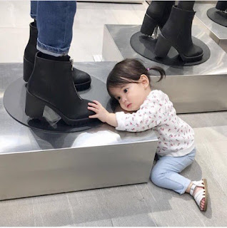 YOUNG BABY GIRL LOOKING AT SHOES