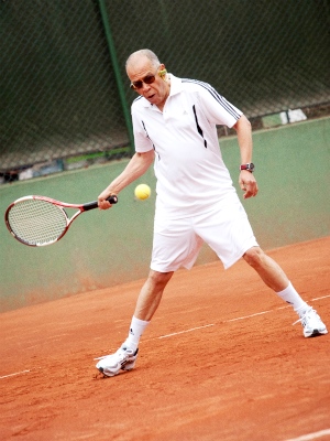 Foto de un hombre de tercera edad jugando tenis