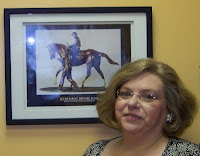 In her Kentucky Insurance Office, Joyce Pinson stands with her print from the Secretariat Bronze Fund