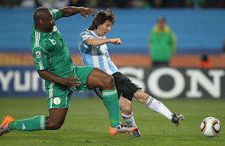  Lionel Messi of Argentina's national football team takes a shot under pressure by Danny shittu of Nigeria during 2010 FIFA World Cup South Africa Group B, Match between Argentina and Nigeria at Ellis Park Stadium on June 12 in Johannesburg, South Africa.