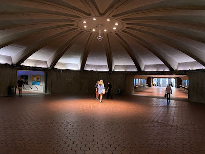 Photo of a big circular indoor space with an arched roof and two visible exits off of it.