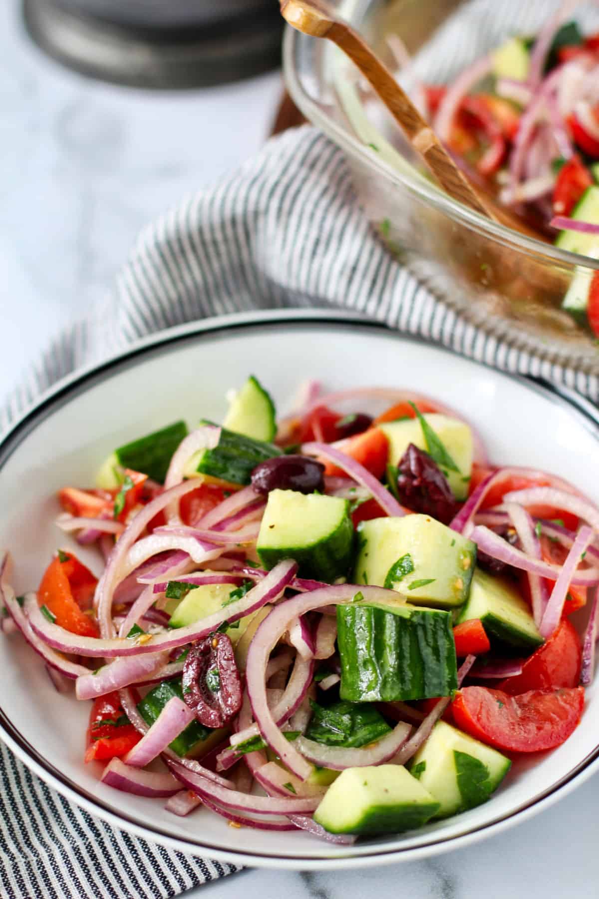Greek salad with olive oil and lemon dressing in a bowl.