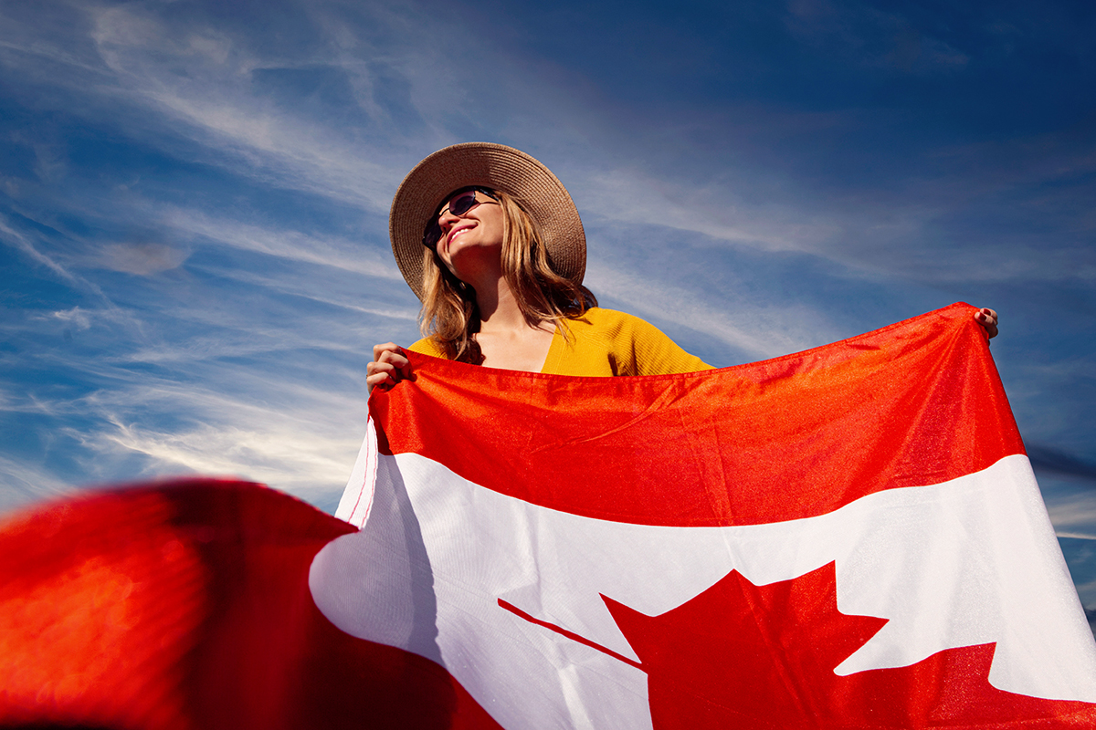 woman holding canadian flag and smiling