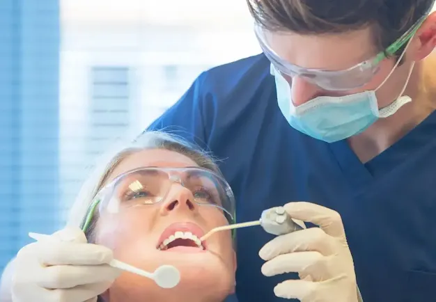 A doctor removing a wisdom teeth from a woman