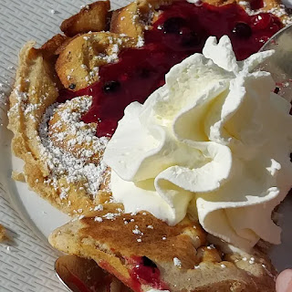 eine Waffel mit Roten Grütze und Schlagsahne