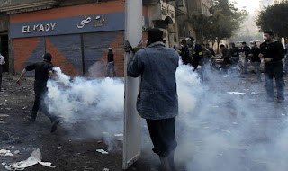 An Egyptian protester takes cover behind a shield