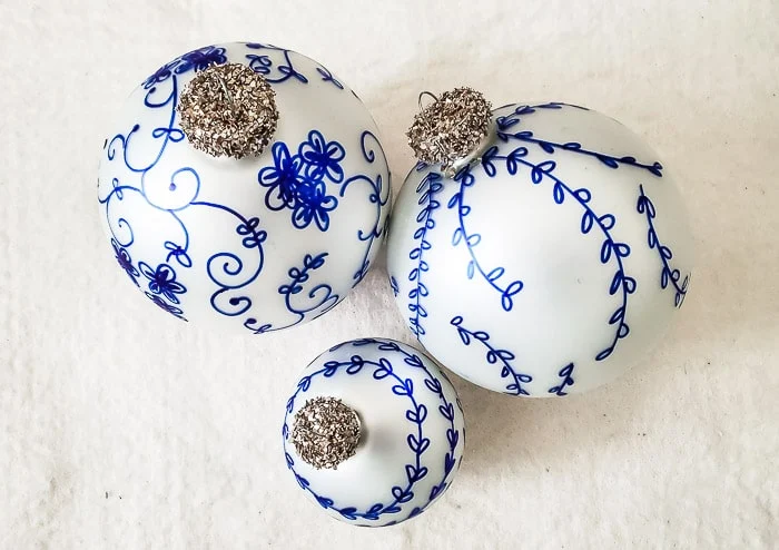 blue and white ornaments with gold glittered tops