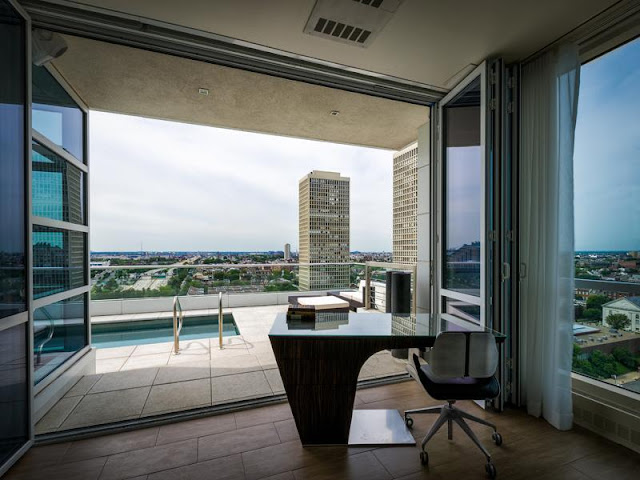 Photo of working desk by the open doors to the pool terrace