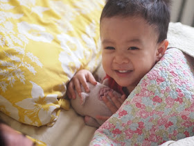 child smiling while mom tells him a story